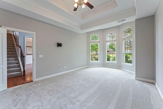unfurnished room with ceiling fan, visible vents, baseboards, carpet flooring, and stairs