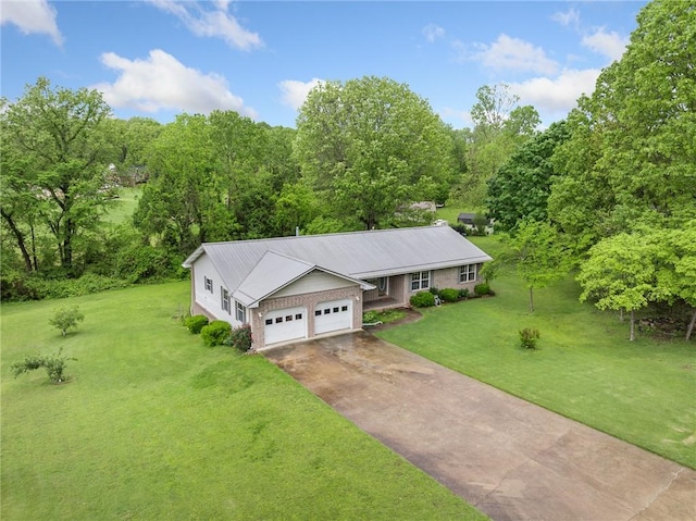 view of front of home featuring a garage, metal roof, a front yard, and concrete driveway
