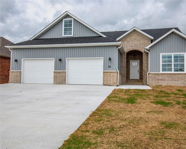 craftsman-style home with board and batten siding, an attached garage, driveway, and a front lawn