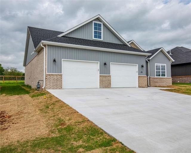 view of front of house featuring roof with shingles, an attached garage, concrete driveway, and brick siding
