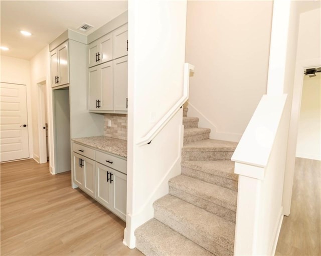stairs featuring recessed lighting, visible vents, and wood finished floors