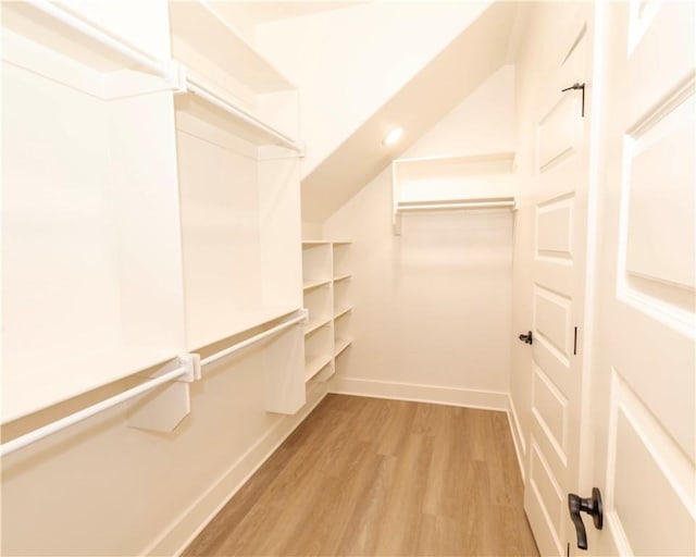 walk in closet with light wood-style floors