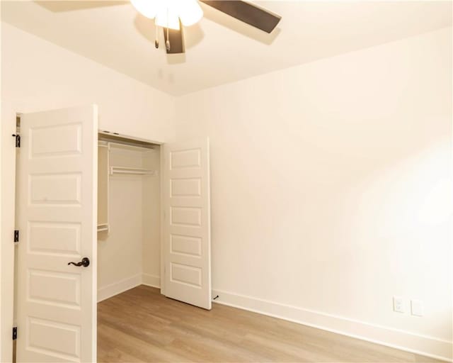 unfurnished bedroom featuring baseboards, a ceiling fan, a closet, and light wood-type flooring