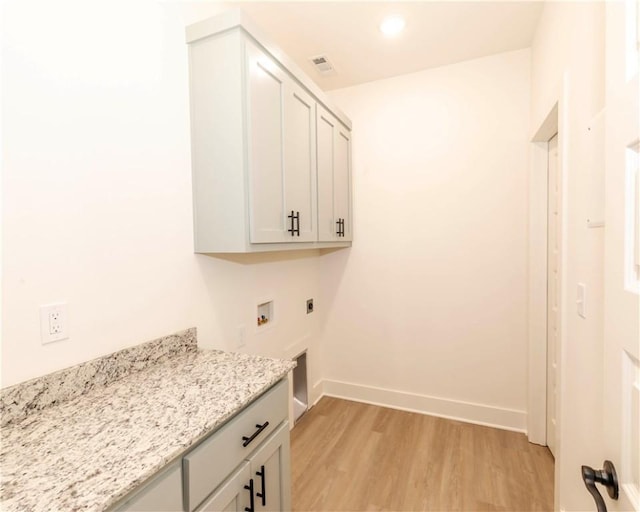 laundry area with visible vents, hookup for a washing machine, light wood-type flooring, electric dryer hookup, and cabinet space
