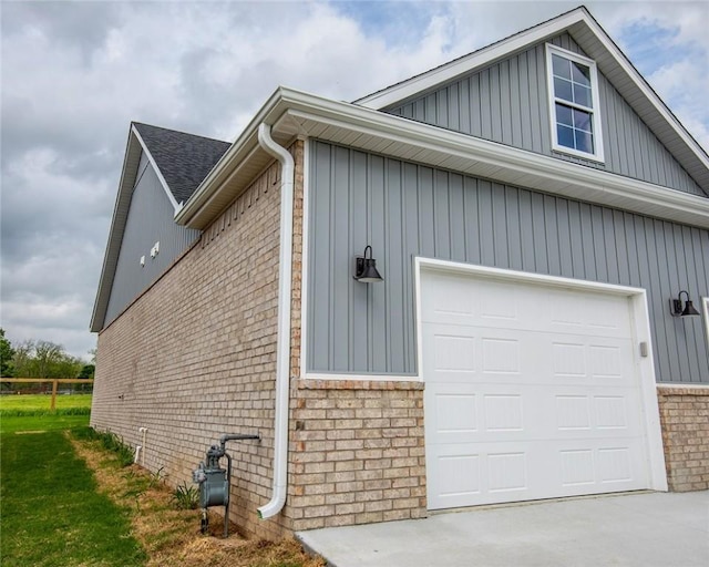 view of side of home with brick siding, a garage, board and batten siding, and driveway