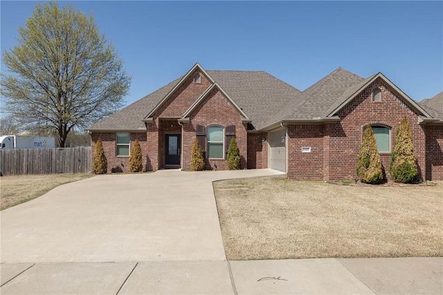 4008 SW Roundstone Blvd, Bentonville, AR 72713 - view of front of home with concrete driveway, brick siding, an attached garage, and fence