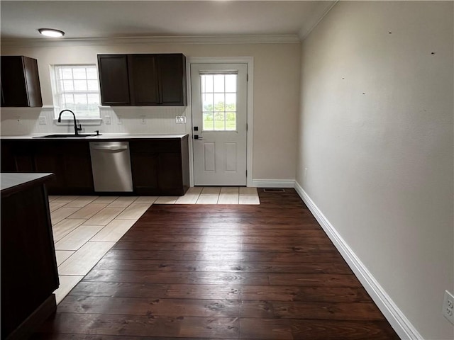 kitchen featuring a sink, light countertops, light wood-style flooring, stainless steel dishwasher, and ornamental molding