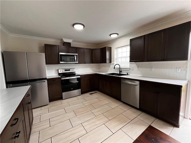 kitchen with a sink, dark brown cabinetry, ornamental molding, and stainless steel appliances