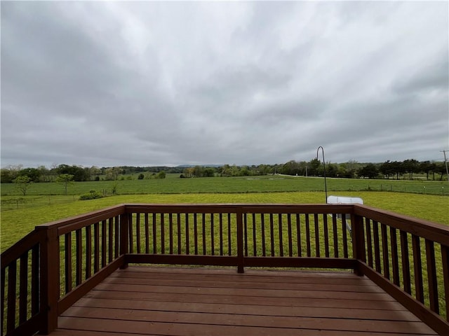 wooden terrace with a lawn and a rural view