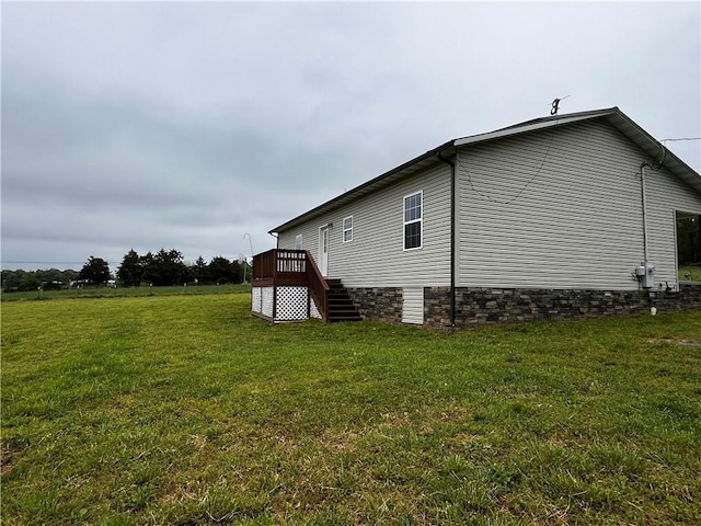 view of home's exterior featuring a lawn, stairway, and a deck