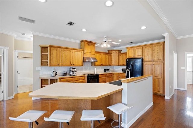 2314 W 7th St, Russellville, AR 72801 - kitchen featuring a ceiling fan, visible vents, a large island with sink, ventilation hood, and black appliances