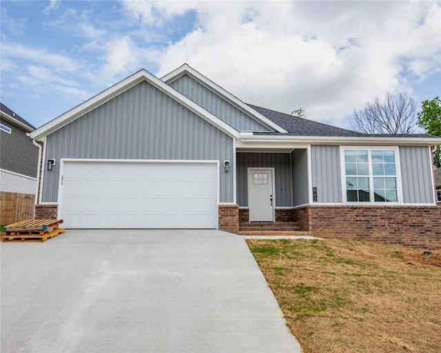 view of front facade with board and batten siding, brick siding, an attached garage, and concrete driveway