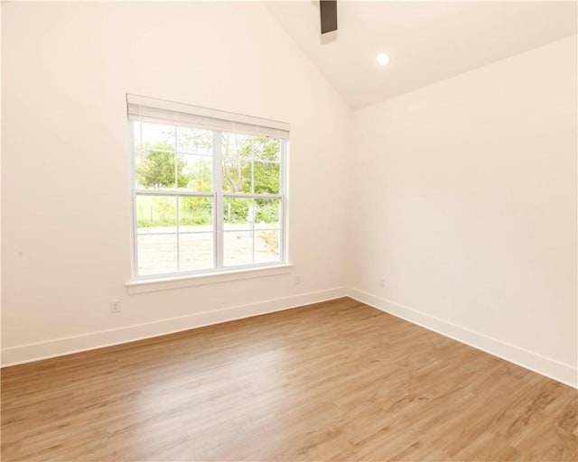empty room with recessed lighting, baseboards, light wood finished floors, and lofted ceiling