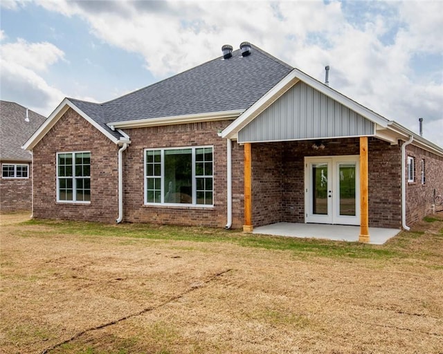 back of house with a lawn, french doors, brick siding, and a patio