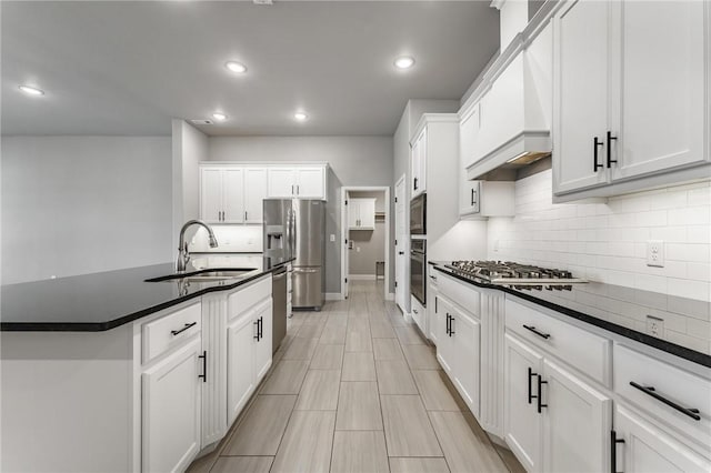 kitchen featuring dark countertops, baseboards, tasteful backsplash, a sink, and appliances with stainless steel finishes