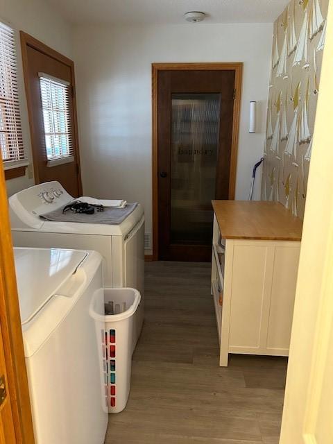 washroom with washing machine and dryer and light wood-type flooring