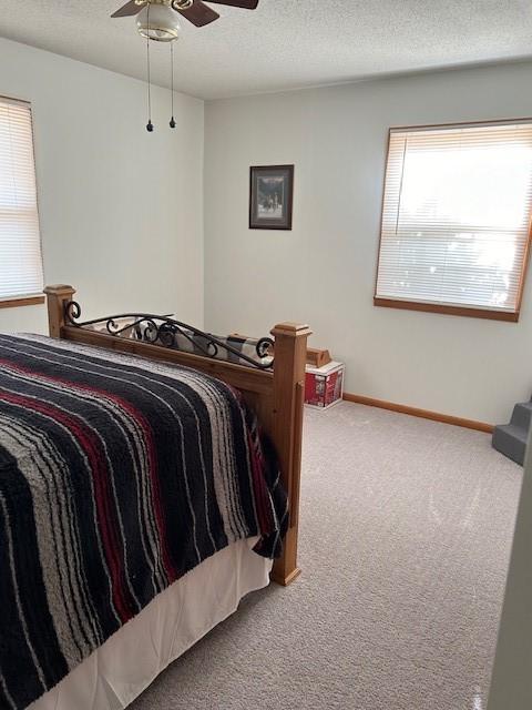 bedroom featuring carpet floors, a ceiling fan, a textured ceiling, and baseboards