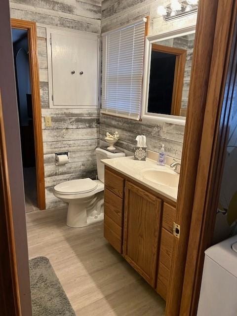 bathroom featuring toilet, wood finished floors, and vanity