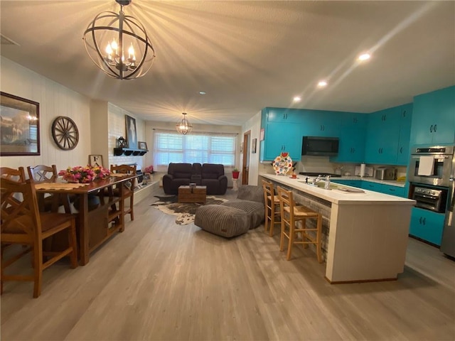 503 Skyline Dr, Harrison, AR 72601 - kitchen featuring stainless steel appliances, a chandelier, light countertops, light wood-style flooring, and a kitchen breakfast bar