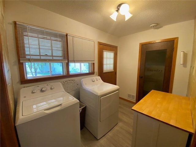 503 Skyline Dr, Harrison, AR 72601 - washroom with washing machine and dryer, light wood-style flooring, and a textured ceiling