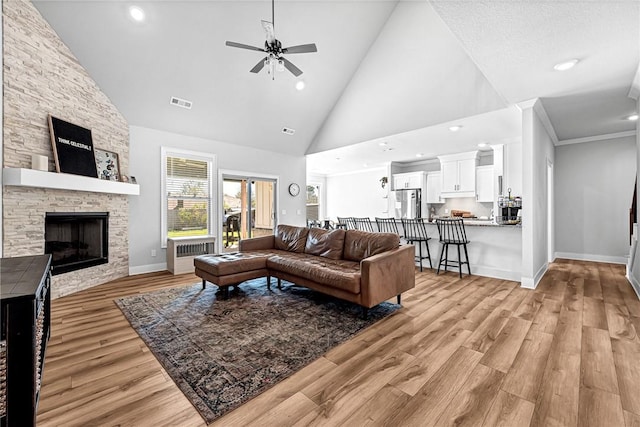 1701 S 23rd Pl, Rogers, AR 72758 - living room with light wood finished floors, a fireplace, high vaulted ceiling, a ceiling fan, and recessed lighting