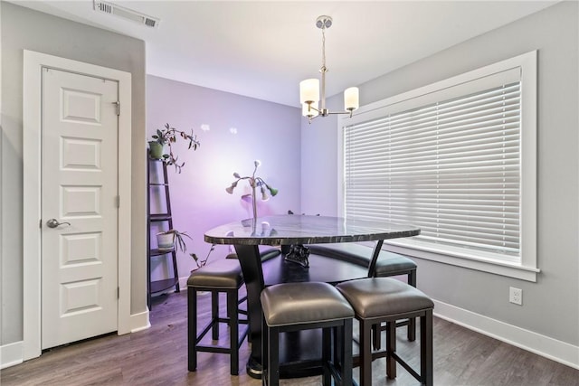dining area featuring a notable chandelier, visible vents, dark wood-style floors, and baseboards