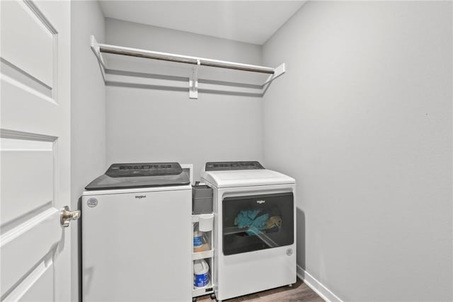 laundry area with separate washer and dryer, laundry area, and wood finished floors