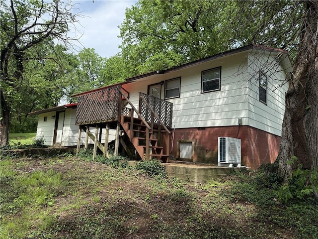 rear view of house with a wooden deck and stairway