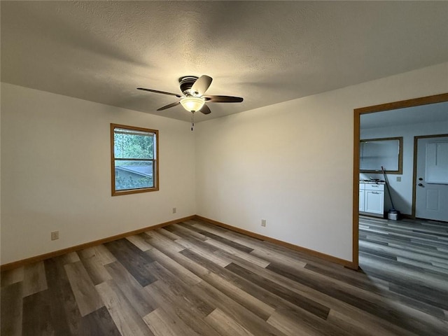 spare room featuring a ceiling fan, baseboards, and wood finished floors
