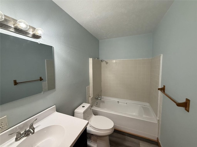 bathroom featuring washtub / shower combination, vanity, toilet, a textured ceiling, and wood finished floors