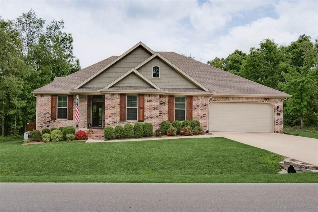 62 Kirkwall Dr, Bella Vista, AR 72715 - craftsman inspired home with an attached garage, a front lawn, driveway, and brick siding