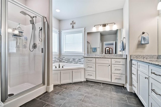 bathroom featuring a garden tub, a stall shower, and vanity