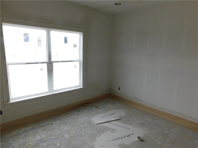 unfurnished room with baseboards