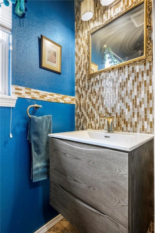 bathroom with vanity, a textured wall, and tile walls
