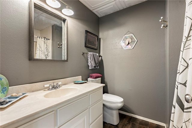bathroom featuring toilet, wood finished floors, and vanity