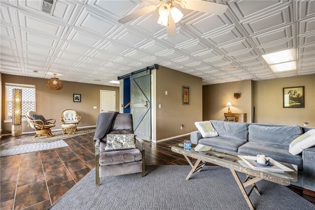 living room with visible vents, baseboards, an ornate ceiling, a barn door, and a ceiling fan