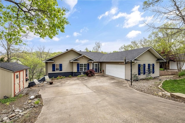 ranch-style home with an outbuilding, an attached garage, and concrete driveway