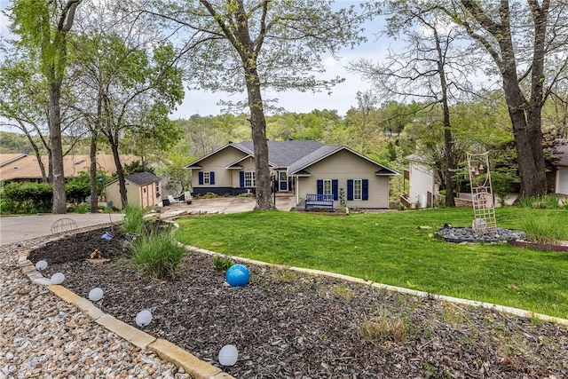 back of house with a storage unit, a lawn, and an outbuilding
