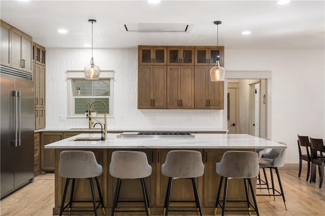 13248 N Old Wire Rd, Rogers, AR 72756 - kitchen with stainless steel built in fridge, a sink, an island with sink, light wood-style flooring, and glass insert cabinets