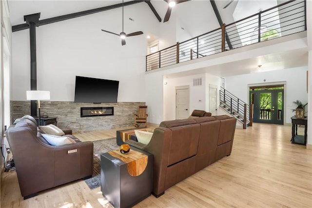 13248 N Old Wire Rd, Rogers, AR 72756 - living area featuring ceiling fan, high vaulted ceiling, stairway, wood finished floors, and a glass covered fireplace