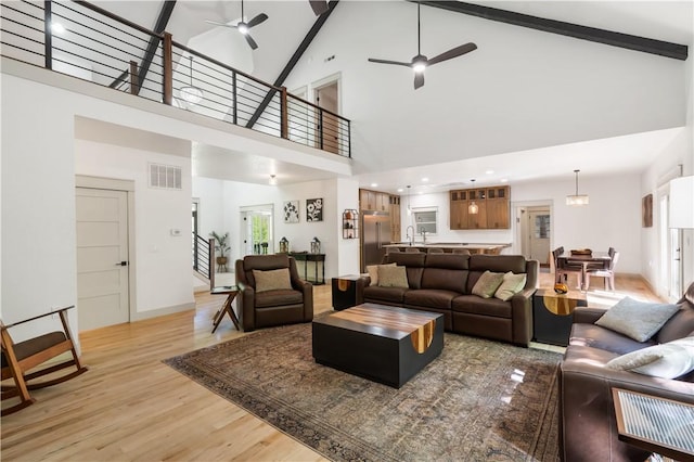 13248 N Old Wire Rd, Rogers, AR 72756 - living area featuring ceiling fan, light wood-style floors, high vaulted ceiling, stairway, and beam ceiling