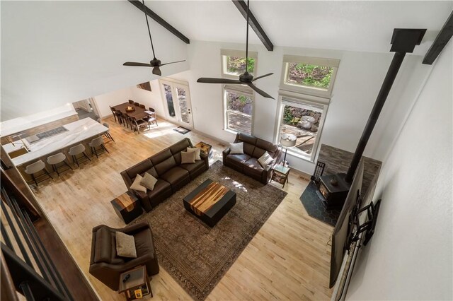13248 N Old Wire Rd, Rogers, AR 72756 - living area with a wood stove, wood finished floors, a ceiling fan, beamed ceiling, and high vaulted ceiling