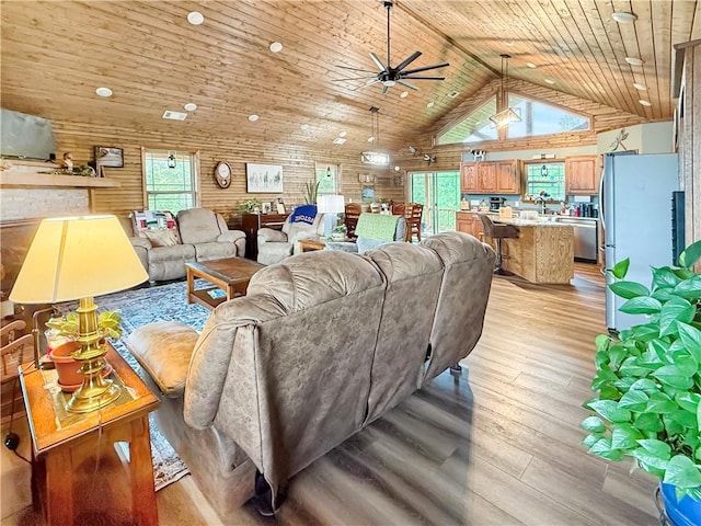 living room featuring light wood-type flooring, ceiling fan, wooden ceiling, and high vaulted ceiling