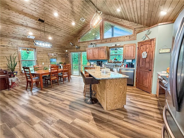 kitchen featuring high vaulted ceiling, a center island, light wood-type flooring, wood ceiling, and appliances with stainless steel finishes