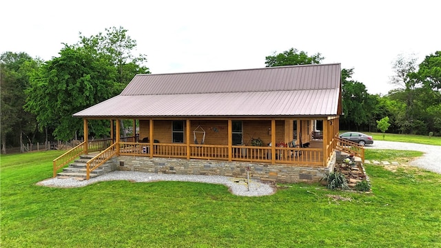 view of front of house with metal roof, a porch, and a front lawn
