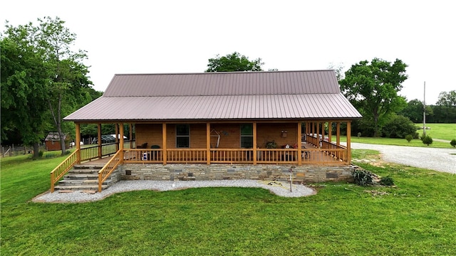 country-style home featuring a storage unit, an outdoor structure, a front lawn, and covered porch