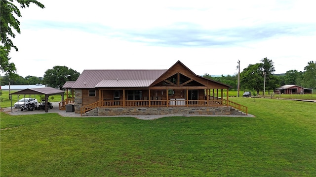 back of property featuring a lawn, metal roof, covered porch, and a carport
