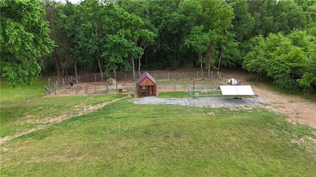 view of storm shelter with an outdoor structure, fence, and a yard
