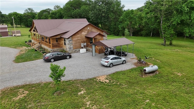 view of front of property featuring driveway, metal roof, and a front yard