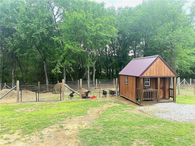 view of yard featuring an outdoor structure, fence, and a gate